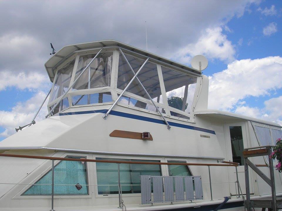 Boat with custom canvas enclosure at dock.